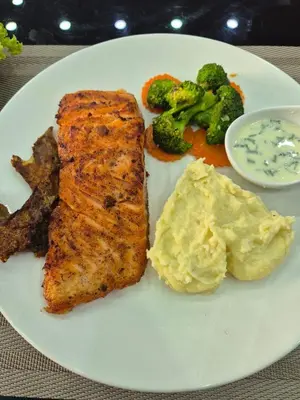 a plate of food with meat and mashed potatoes and broccoli at New Forest Patong Hotel, Patong Beach in Patong Beach