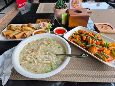 a table with a bowl of soup and a tray of food at New Forest Patong Hotel, Patong Beach in Patong Beach