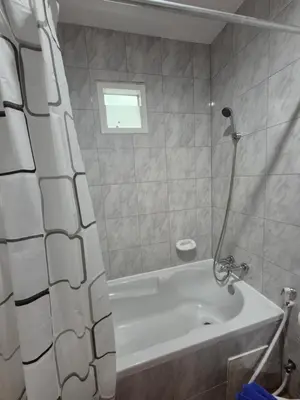 a white bath tub in a bathroom with a window at New Forest Patong Hotel, Patong Beach in Patong Beach