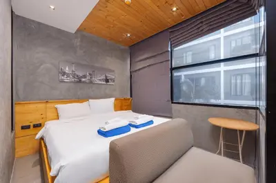 a bedroom with a bed and a chair and a window at Relife Kai 2 min to Nai Harn beach by TropicLook in Rawai Beach