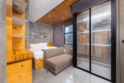 a small bedroom with a bed and a chair at Relife Kai 2 min to Nai Harn beach by TropicLook in Rawai Beach