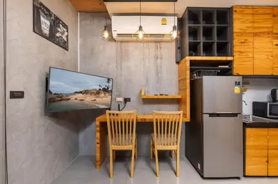 a kitchen with a table and two chairs and a refrigerator at Relife Kai 2 min to Nai Harn beach by TropicLook in Rawai Beach