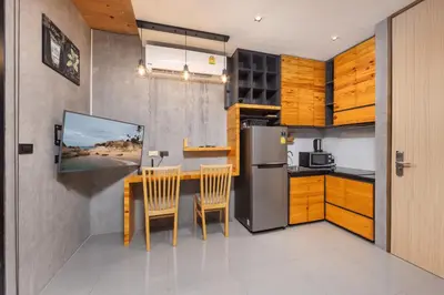a kitchen with a refrigerator and a table with chairs at Relife Rio 2 min to Nai Harn beach in Rawai Beach
