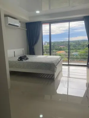 a bedroom with a bed and a large window at май кхао Студия в кондо 777 in Koh Lone