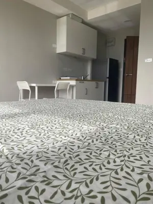 a room with a large bed with chairs and a kitchen at май кхао Студия в кондо 777 in Koh Lone