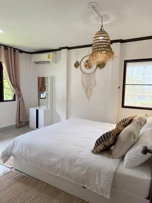 a bedroom with a white bed and a chandelier at Jungle style villa 3br in Kamala Beach