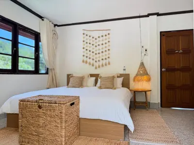 a bedroom with a bed with a wicker ottoman next to it at Jungle style villa 3br in Kamala Beach