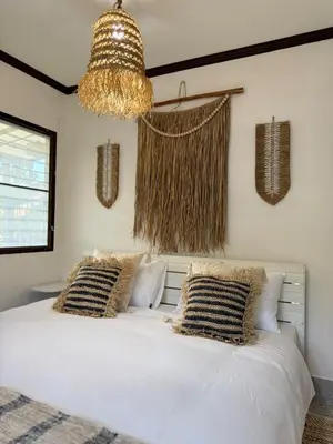a bedroom with a white bed with pillows and a chandelier at Jungle style villa 3br in Kamala Beach