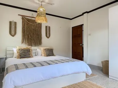 a bedroom with a bed and a chandelier at Jungle style villa 3br in Kamala Beach