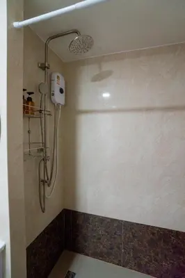 a shower with a glass door in a bathroom at Boho Apartment in Mai Khao Beach