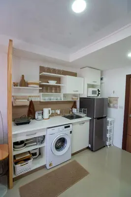 a kitchen with a washing machine and a refrigerator at Boho Apartment in Mai Khao Beach