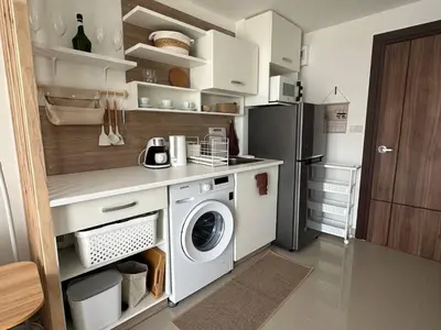 a kitchen with a washing machine and a refrigerator at Boho Apartment in Mai Khao Beach