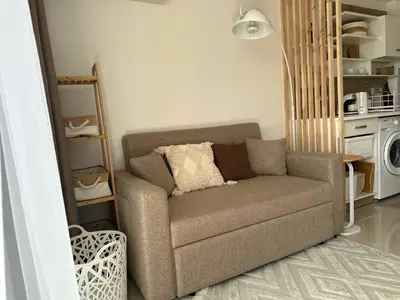 a living room with a couch and a microwave at Boho Apartment in Mai Khao Beach
