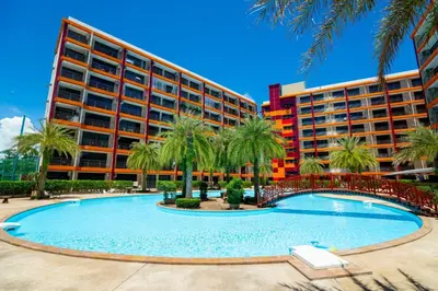 a resort with a large swimming pool in front of a building at Boho Apartment in Mai Khao Beach