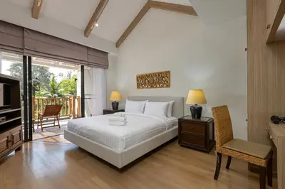 a bedroom with a bed and a television and a balcony at Golden Cotton Villa 3BR Lagoon View by GRF in Laguna Phuket