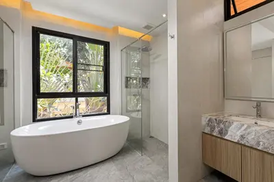 a white bath tub in a bathroom with a window at Golden Cotton Villa 3BR Lagoon View by GRF in Laguna Phuket