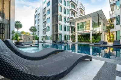 a hotel swimming pool with a hammock in front of a building at Peaceful Bliss With 120 Sqm Kamala Beach in Kathu