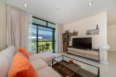 a living room with a white couch and a television at Peaceful Bliss With 120 Sqm Kamala Beach in Kathu