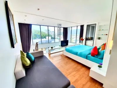a living room with a blue couch and a television at Beautiful Modern Penthouse Kamala Beach in Kamala Beach