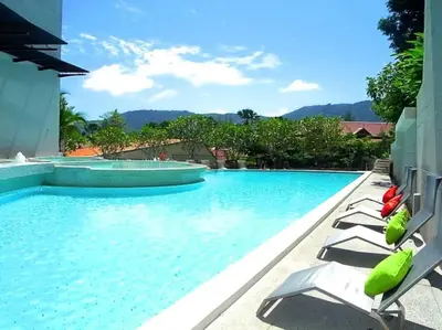 a swimming pool with lounge chairs in a resort at Beautiful Modern Penthouse Kamala Beach in Kamala Beach