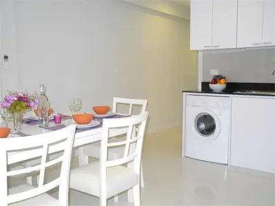 a kitchen with a table and a washing machine at Ideally Apartment close to Kata Beach in Kata Beach