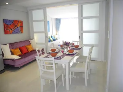 a dining room with a white table and chairs at Ideally Apartment close to Kata Beach in Kata Beach
