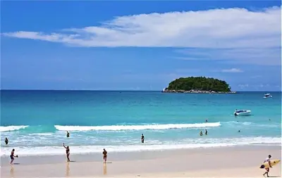 a group of people playing in the water on a beach at Ideally Apartment close to Kata Beach in Kata Beach