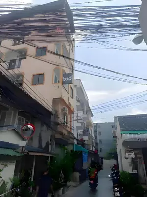 a building on a street with motorcycles parked next to it at XX BAO Patong Beach Phuket - เบา ป่าตอง in Patong Beach