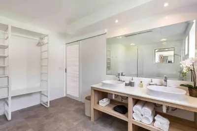 a bathroom with two sinks and a large mirror at Villa Sand in Pilai Beach