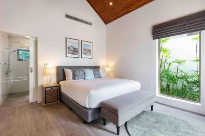 a bedroom with a bed and a large window at Villa Sand in Pilai Beach