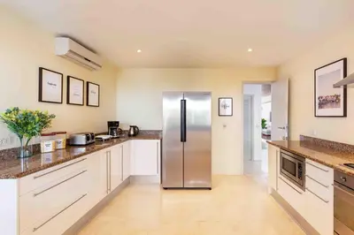 a large kitchen with a stainless steel refrigerator at Villa Sand in Pilai Beach