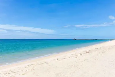 a beach with the ocean and a blue sky at Villa Sand in Pilai Beach