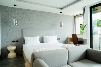a bedroom with a white bed and a couch at Utopia Karon in Kata Beach