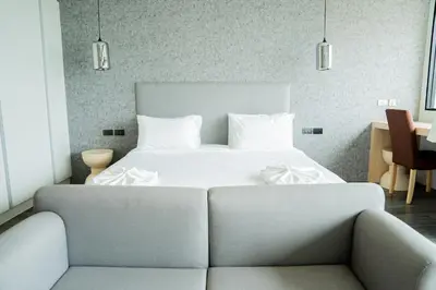 a bedroom with a white bed and a couch at Utopia Karon in Kata Beach