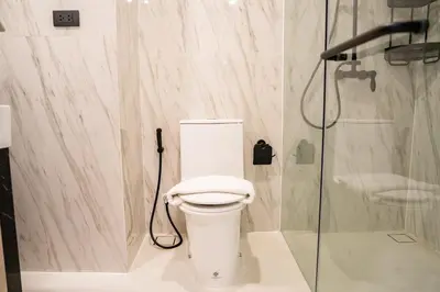 a bathroom with a toilet and a shower at Utopia Karon in Kata Beach