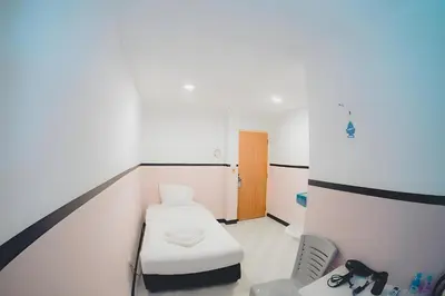 a hospital room with a bed and a chair at xx Mitr INN Phuket Oldtown - มิตร ภูเก็ต in Phuket Town