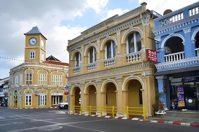 a yellow building with a clock tower on a street at xx Mitr INN Phuket Oldtown - มิตร ภูเก็ต in Phuket Town