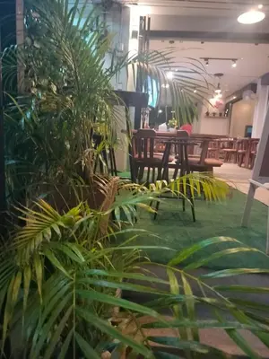 a group of plants in a room with tables at the three pyramids in Rawai Beach