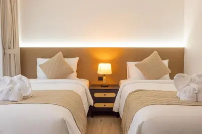a hotel room with two beds and a lamp at XL PATONG Hotel in Patong Beach