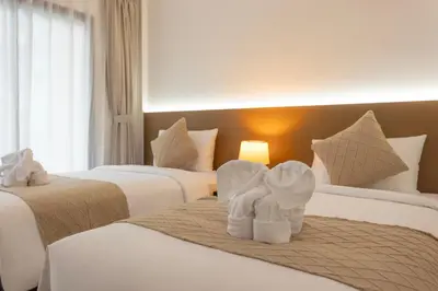 two towels on two beds in a hotel room at XL PATONG Hotel in Patong Beach