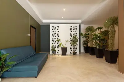a living room with a blue couch and potted plants at XL PATONG Hotel in Patong Beach