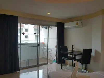 a room with a bed and a desk and a window at Sea Breeze Patong Holiday Condo in Patong Beach