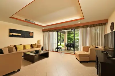 a living room with a couch and a tv at Tropical Holiday Home at Laguna Phuket in Layan Beach