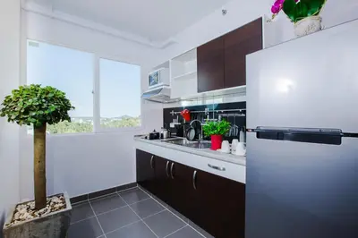 a white kitchen with a refrigerator and a potted plant at W Phuket in Phuket Town