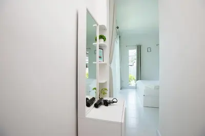 a white bathroom with a white vanity and a mirror at The White House Kamala Beachfront in Kamala Beach