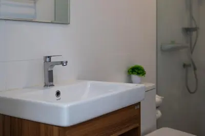 a bathroom with a white sink and a toilet at The White House Kamala Beachfront in Kamala Beach