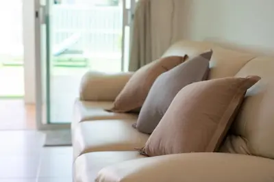 a row of pillows on a couch in a living room at The White House Kamala Beachfront in Kamala Beach