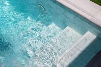 a swimming pool with water splashing in it at The White House Kamala Beachfront in Kamala Beach