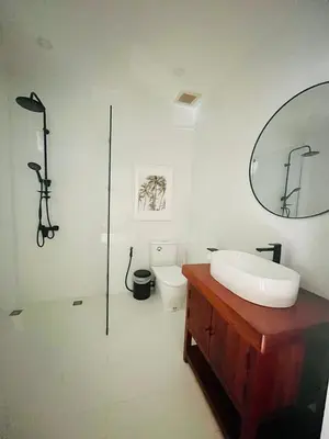 a bathroom with a sink and a mirror and a toilet at Coastal Villa on Fairway in Phuket