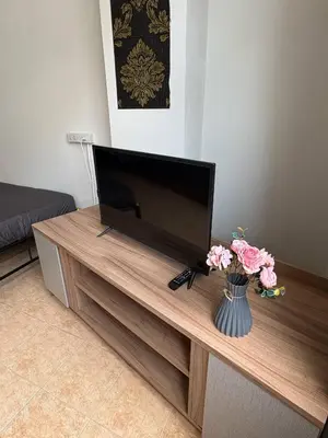 a flat screen tv sitting on top of a wooden entertainment center at Mamma Mia Rooms in Kata Beach